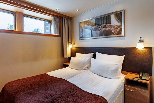 Komfortable Hauptdeck-Kabine auf einem A-ROSA Flussschiff mit Fensterblick und modernem Interieur