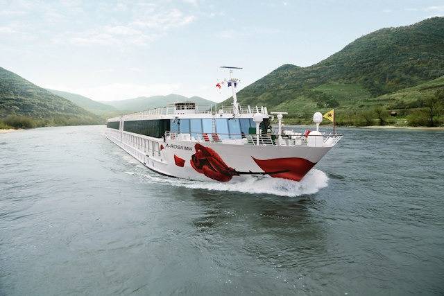 Flussschiff A-ROSA MIA von vorn mit roter Rose am Bug, auf der Donau unterwegs