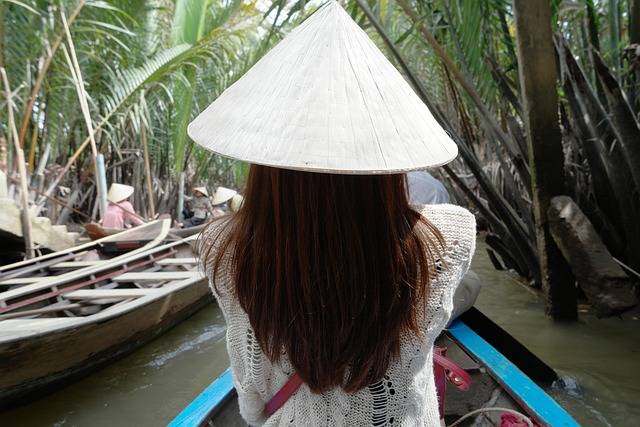 Traditionelles Flussschiff auf dem Mekong bei Sonnenuntergang